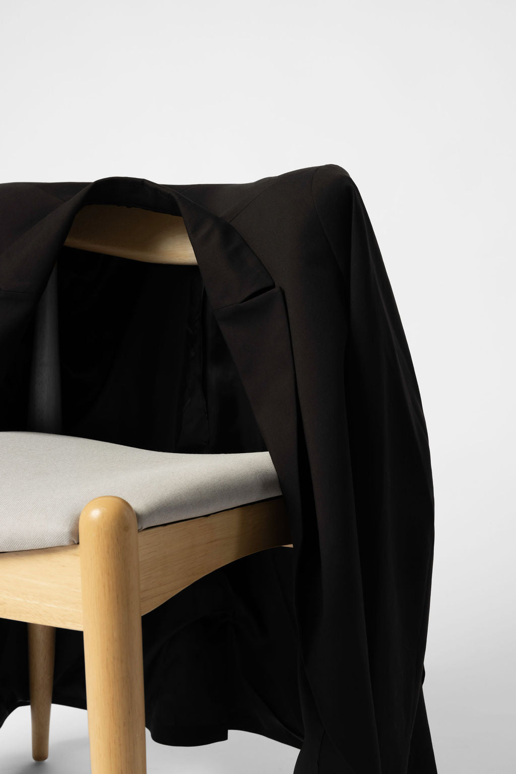 Minimalist Capsule Wardrobe Black Blazer Draped over a chair